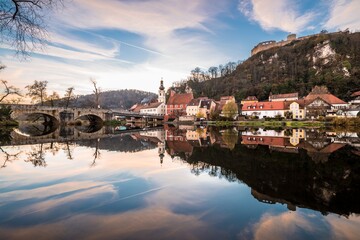 Fototapeta na wymiar Bild einer Panorama Stadtansicht des Markt Kallmünz Kallmuenz zur blauen Stunde während Sonnenuntergang in Bayern und dem Fluss Naab Vils und der Burg Ruine auf dem Berg, Deutschland