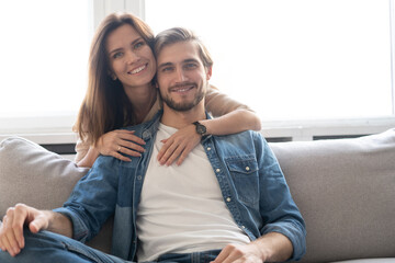 Obraz premium Happy couple or marriage hugging and enjoying in a couch at home.