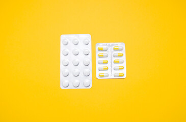 Medical capsules, pills on a yellow background. Copy space