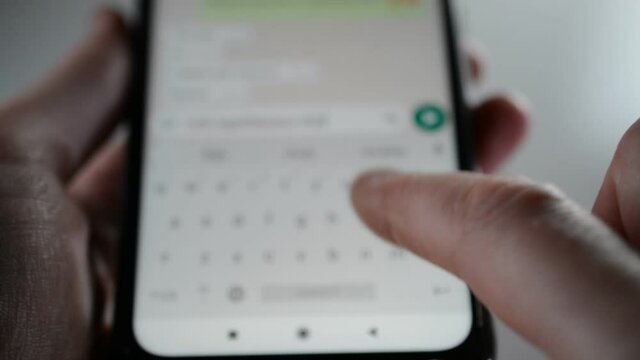 close hands typing a message on the phone