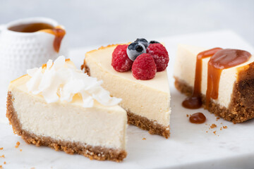 Cheesecake slices with various toppings. Choice of cheesecakes. Caramel sauce, berries and vegan coconut cashew cheesecake