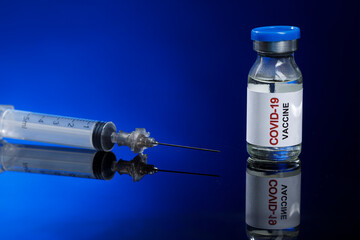 Flacone di vaccino contro il coronavirus con  Siringa , isolati su sfondo blu