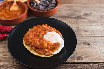 Huevos rancheros Mexican breakfast on a wooden base. Mexican cuisine. Copy space.