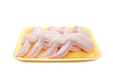 Raw Chicken wings in a yellow polystyrene container isolated on white background. Four fresh chicken parts for cooking. Side view.
