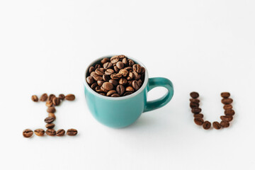 A Cup with coffee beans and letters made of coffee beans on a white background. creative photo of coffee. suitable for Valentine day, cafe, restaurants and wallpapers. But first coffee love concept.
