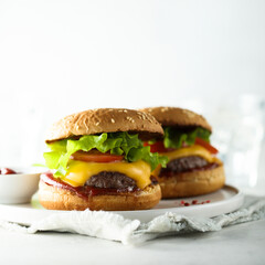 Traditional homemade cheeseburgers on a white plate