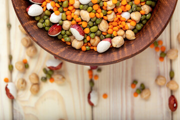 Bowl with different raw legumes on table close up, top view, copy space. Vegan protein source