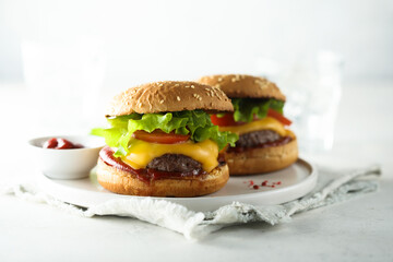Traditional homemade cheeseburgers on a white plate