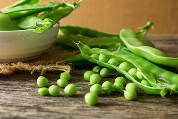 Pile of snow peas on wood background.