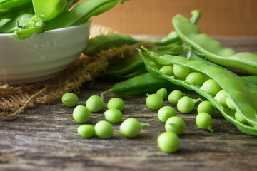 Pile of snow peas on wood background.