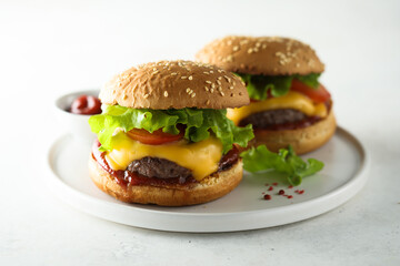Traditional homemade cheeseburgers on a white plate