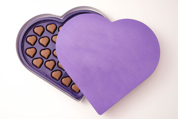 chocolate pralines lie in a box, which is also heart-shaped and covered with a lid