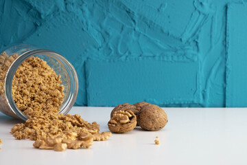 peeled walnuts in a glass jar scattered on a table