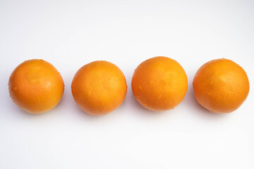 four fresh oranges are laid out in a row on a table