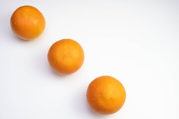 three fresh oranges are laid out in a row on a table