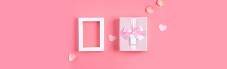 Valentine's Day design concept background with pink petals and gift box.