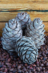 Fototapeta na wymiar Pine nuts. Pine nuts and cones on a wooden table. Seeds of Siberian pine in the shell