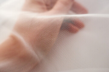 girl holding a soft white tulle , macro