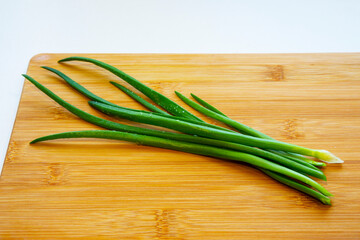 Fresh green onions on a cutting board. Drops of water on a fresh cut green onion.
