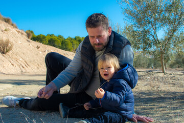 Portrait of cheerful father and son couple outdoor together - happy family outdoors.