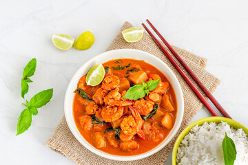 Thai Prawn Massaman Curry in a Bowl with Chopsticks Garnished with Basil Leaves and Lemon Top Down Food Photo