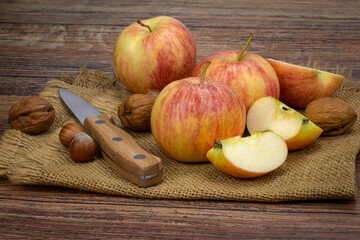 pommes, noix et noisettes sur une table en bois