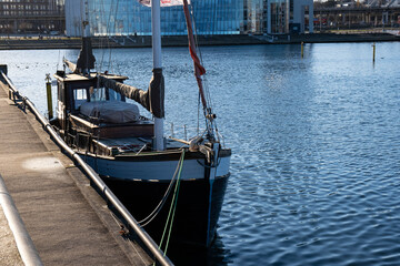 Fototapeta na wymiar old fishing boat in the harbor of a big city