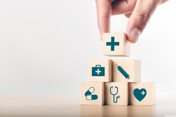 Hand arranging wood block stacking with the healthcare medical icon. Health insurance - health...