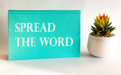 Text Spread the word on a green notepad and white background. Business concept for launch advertising to increase sales