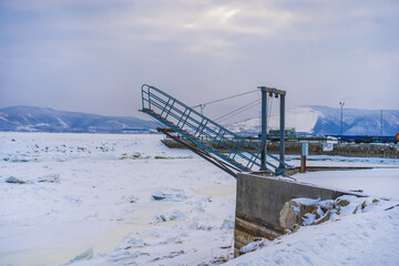 A special ladder for launching yachts and boats into the water. Winter time, frozen river