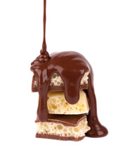 Porous chocolate pieces and chocolate syrup, isolated on white background. White aerated chocolate.