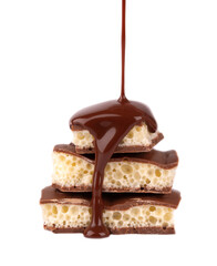 Porous chocolate pieces and chocolate syrup, isolated on white background. White aerated chocolate.