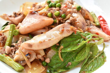 spicy chili fried squid with mashed pork and fresh pepper couple basil leaf on plate