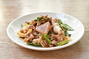 spicy chili fried squid with mashed pork and fresh pepper couple basil leaf on plate