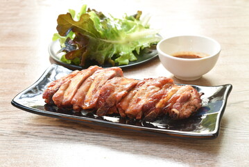 grilled pork bone slice dipping spicy chili sauce eat couple fresh vegetable on plate