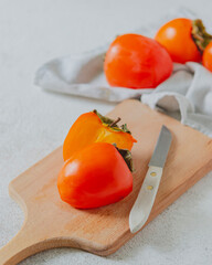 Ripe juicy orange persimmon on a wooden board