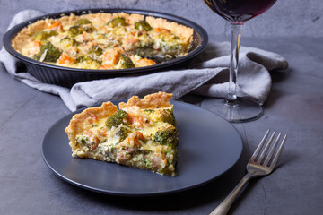 Quiche (open pie) with trout, broccoli and cheese. Homemade unsweetened pastries, traditional pie. Close-up.
