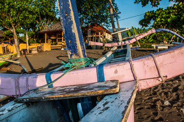 Fototapeta na wymiar Atardecer en la playa en Bali con barcos fondeados en la arena. Lovina. 