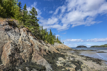 Fototapeta na wymiar Picturesque View of the Bic Park (Parc national du Bic): rocks and forest on shore of the St. Lawrence River. Bas-Saint-Laurent tourism region near Rimouski, Quebec Province, Canada.