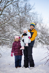 Three children on a walk in winter, a teenager