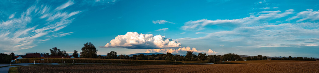 High resolution stitched panorama of a summer landscape with a fascinating cloud above the Bavarian forest seen from near Osterhofen, Danube, Bavaria, Germany
