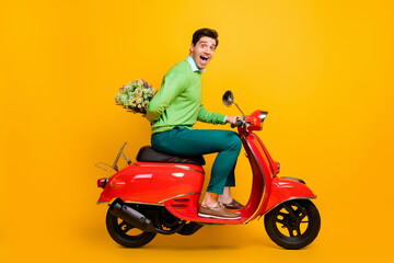 Fototapeta na wymiar Full size profile portrait of funny person sit moped hide flower behind back open mouth isolated on yellow color background