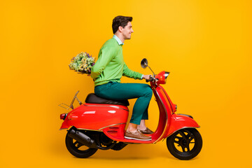 Fototapeta na wymiar Full length profile photo of nice guy driving bike hold flower behind back wear sweater isolated on yellow color background