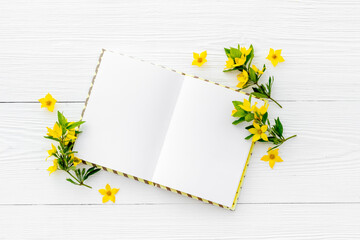 Blank greeting card with yellow flowers, top view. Floral background