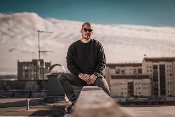 Urban hipster young man posing on top of the ghetto building