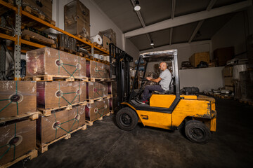 Warehouse man worker with forklift. Warehouse worker driver in loading by forklift stack loader