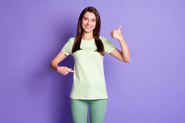 Photo portrait of young girl pointing with finger on belly showing like sign thumb-up smiling...