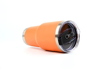 Orange steel  or stainless  thermos mug or cup For keeping heat or cold water put on wooden table isolated on bule pastel background.