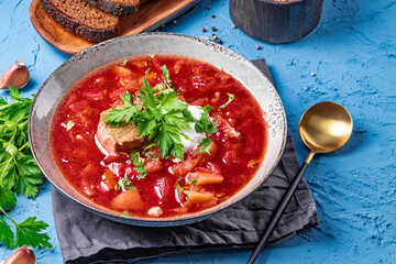 Borscht with sour cream on the table close-up - a dish of traditional Russian and Ukrainian cuisine