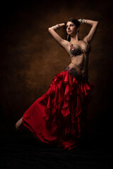 Oriental dancer with a saber. Belly dance. The brunette. Red.
